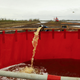 Spilled diesel fuel dredged from the river being poured into containment tanks.